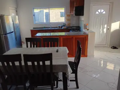 a kitchen with a table and chairs and a refrigerator at Campo do campo ocean view in São Filipe