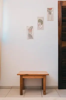a wooden table in front of a white wall with pictures at Maluhia Home - Maio in Calheta Do Maio
