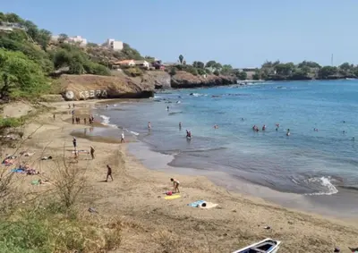 a group of people on a beach in the water at Prainha Beach Home in Praia
