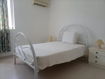 a white bedroom with a white bed and a window at Prainha Beach Home in Praia