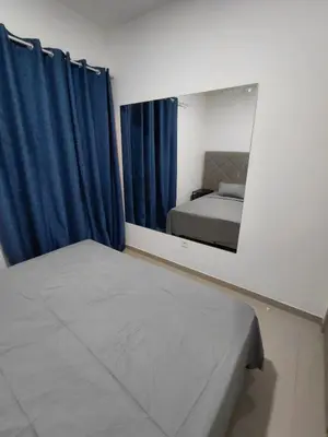 a bedroom with a mirror and a bed with blue curtains at C&C Guesthouse in Praia