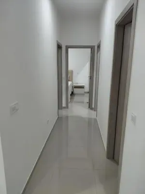 a corridor of a room with white walls and white floors at C&C Guesthouse in Praia