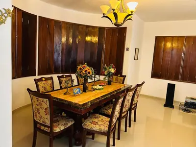 a dining room with a wooden table and chairs at Villa Esperança in Tarrafal