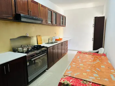 a kitchen with a stove and a table in it at Villa Esperança in Tarrafal