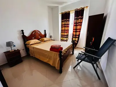 a bedroom with a bed and a chair in it at Villa Esperança in Tarrafal