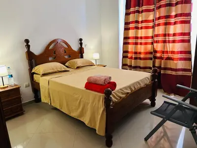 a bedroom with a bed with a wooden head board at Villa Esperança in Tarrafal