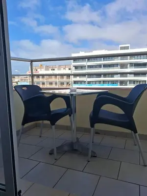 a table and chairs on a balcony with a building at Apartamento Estoril in Sal Rei