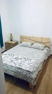 a bedroom with a bed with a wooden headboard at Sunset Serenity 2BR Home 5Min To The Beach in Praia
