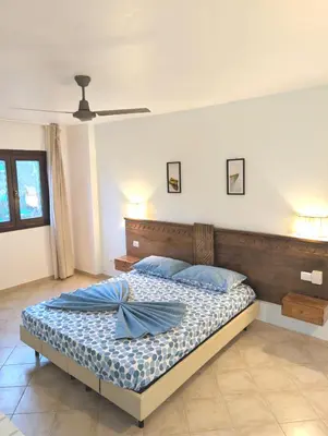 a bedroom with a bed with blue pillows at SUNSENT GLOW - Tropical Apt N11 - PointingCaboVerde in Santa Maria