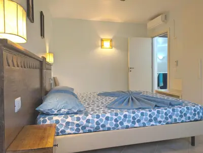 a bedroom with a bed with blue pillows on it at SUNSENT GLOW - Tropical Apt N11 - PointingCaboVerde in Santa Maria