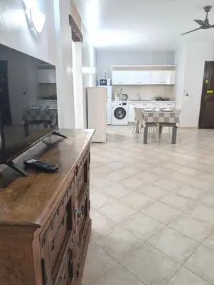 a kitchen and dining room with a table and refrigerator at SUNSENT GLOW - Tropical Apt N11 - PointingCaboVerde in Santa Maria