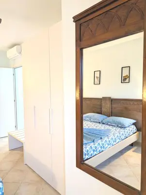 a mirror in a bedroom with a bed at SUNSENT GLOW - Tropical Apt N11 - PointingCaboVerde in Santa Maria