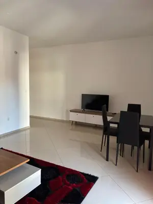 a living room with a table and a tv on a wall at La casa de iman in Praia