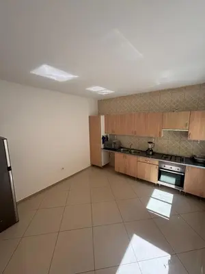 a large kitchen with wooden cabinets and stainless steel appliances at La casa de iman in Praia