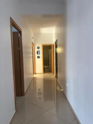 a hallway with white walls and a white tile floor at La casa de iman in Praia