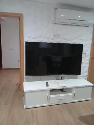 a large white entertainment center with a large flat screen tv at T&S Guest House in Praia