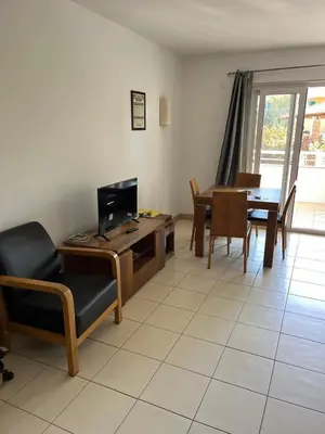 a living room with a tv and a table and chairs at Vila Verde cozy studio in Prainha