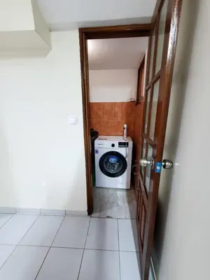 a bathroom with a washing machine in a room at Comfort T2 in Espargos