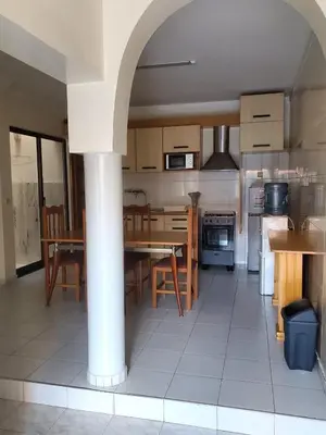 a kitchen with a table and chairs and a kitchen with a column at Comfort T2 in Espargos