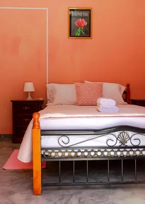 a bed in a room with an orange wall at Quinta Toca do leão in Ribeira Grande
