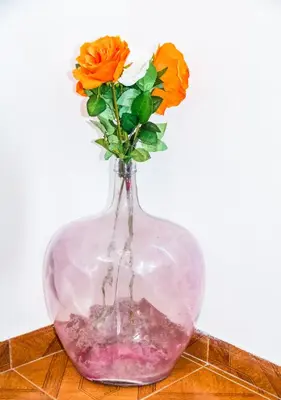 a clear glass vase with orange flowers in it at Quinta Toca do leão in Ribeira Grande