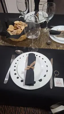 a table with a plate with a napkin and wine glasses at Diva Apartamento in Praia