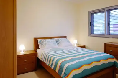 a bedroom with a bed with two night stands and a window at Private Apartament Celestina & Carlos in Mindelo