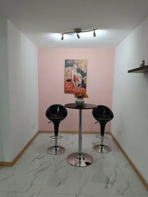 a table and two stools in a room with a painting at Apartament in Praia in Praia