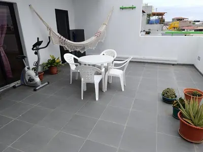 a patio with a hammock and a table and chairs at Apartament in Praia in Praia