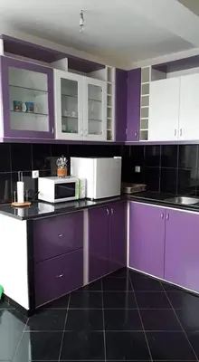 a kitchen with purple and white cabinets and appliances at Chez Zuzu in Mindelo