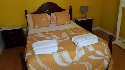 a bedroom with a large bed with towels on it at Chez Zuzu in Mindelo