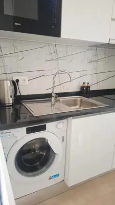 a kitchen with a sink and a washing machine at Luxury Lux Studio with Seaview in Santa Maria