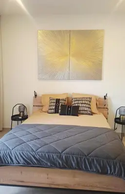 a bedroom with a large bed with a wooden headboard at Luxury Lux Studio with Seaview in Santa Maria