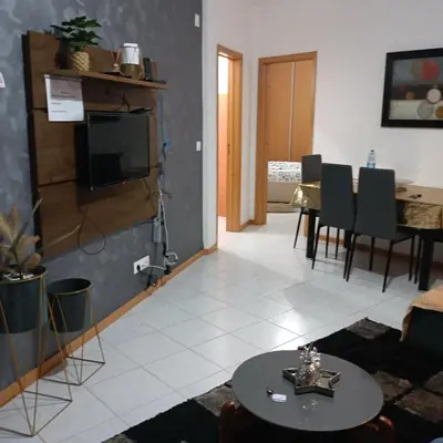 a living room with a tv and a table with chairs at ManubelaRelax in Praia