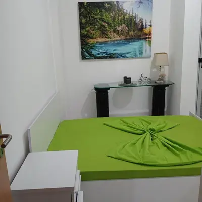 a room with a bed with a green blanket on it at ManubelaRelax in Praia