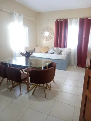 a living room with a table and a bed at ANGÉLICA RÉSIDENCE Centre-ville 350 m plage in Tarrafal