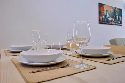 a table with plates and wine glasses on it at Brisa Suites in Santa Maria