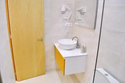 a bathroom with a white sink and a shower at Brisa Suites in Santa Maria