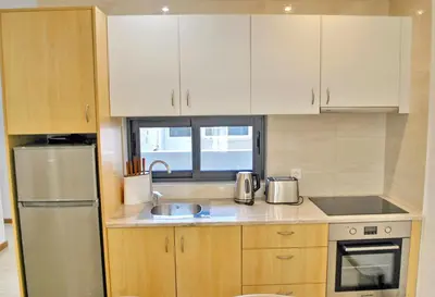 a kitchen with wooden cabinets and a stainless steel refrigerator at Brisa Suites in Santa Maria