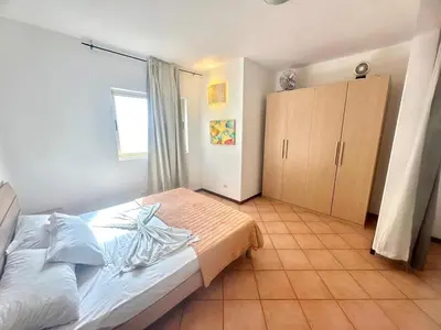 a bedroom with a bed and a wooden cabinet at near the beach On bedroom flat very good in Santa Maria