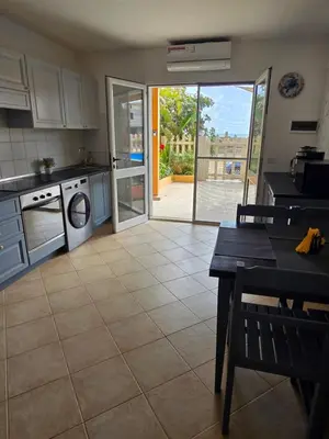 a kitchen with a table and a kitchen with a door open at La Vedetta Bella Vista Ocean View II in Santa Maria