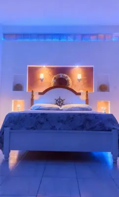 a bedroom with a large bed with blue lighting at Beach Village Rest in Tarrafal