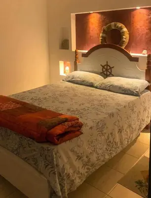 a bedroom with a large bed with a white comforter at Beach Village Rest in Tarrafal
