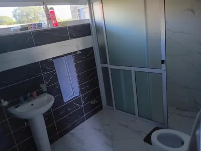 a bathroom with a shower and a sink and a toilet at Ocean view country house in São Filipe