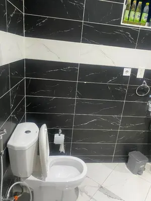 a bathroom with a toilet and a black wall at Ocean view country house in São Filipe