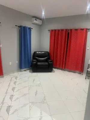 a living room with red and blue curtains and a chair at Ocean view country house in São Filipe
