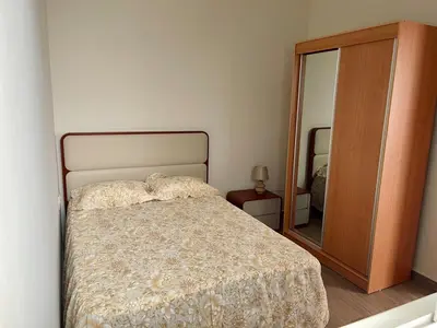 a bedroom with a bed and a large mirror at Brand New 2-Bedroom Apartment with AC & Fast Wi-Fi in São Filipe