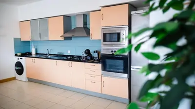 a kitchen with white cabinets and a refrigerator at Sunny & Cosy Flat in Vila Verde near Bikini Beach! in Prainha