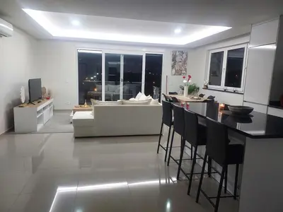 a kitchen and living room with a table and a couch at Appartement Vue Mer in Mindelo