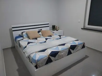 a bed in a bedroom with a white wall at Appartement Vue Mer in Mindelo